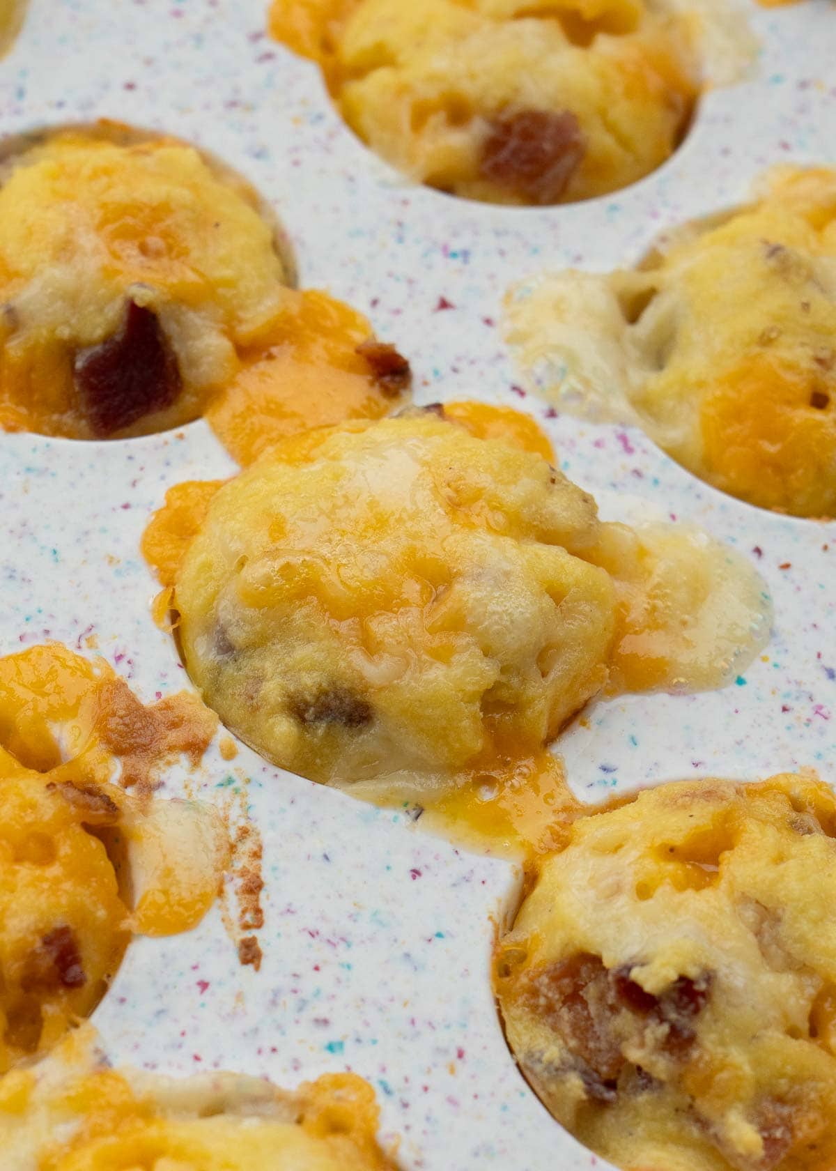 cooked bacon egg and cheese muffins in a muffin pan