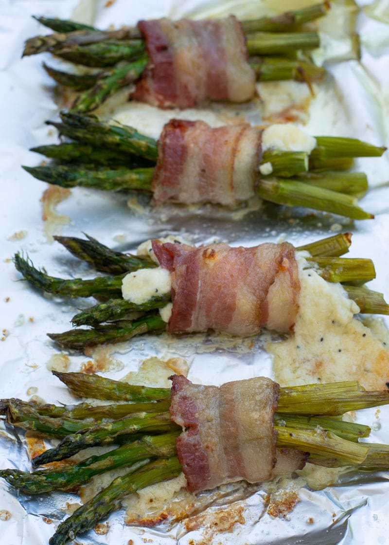 This Cheesy Bacon Wrapped Asparagus is the best keto side dish or appetizer! Enjoy 2 bundles of crispy bacon, tender asparagus, and a creamy parmesan filling for under 3 net carbs!