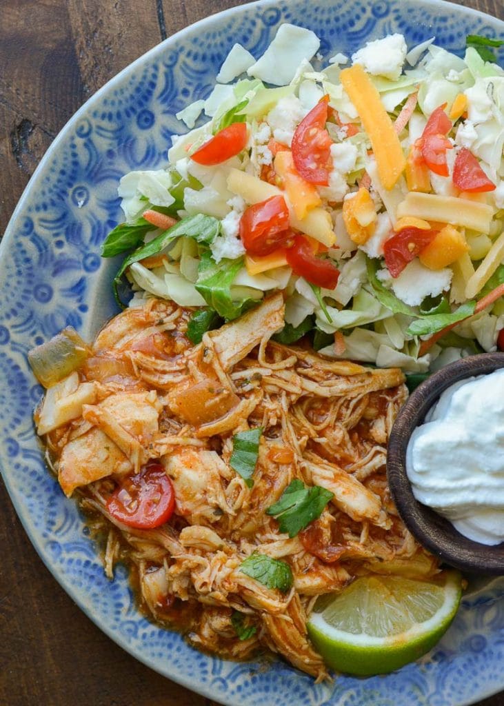 This Crock Pot Salsa Chicken is the best set it and forget it meal! Tender shredded chicken is combined with taco seasoning, enchilada sauce and garlic for a flavor packed easy dinner recipe that is perfect for keto meal prep!