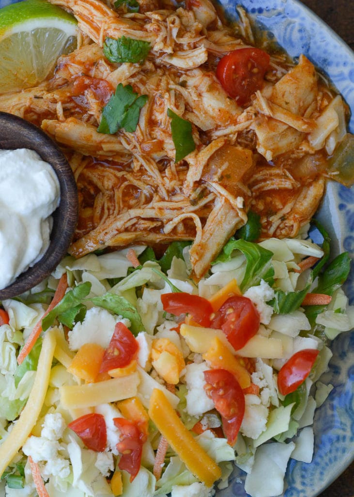 This Crock Pot Salsa Chicken is the best set it and forget it meal! Tender shredded chicken is combined with taco seasoning, enchilada sauce and garlic for a flavor packed easy dinner recipe that is perfect for keto meal prep!