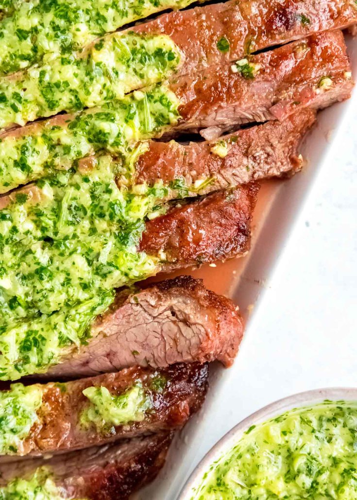 Juicy marinated Flank Steak is grilled to perfection and topped with zesty homemade Chimichurri sauce! This low-carb recipe is perfect for cookouts, parties, or a delicious weekend meal!