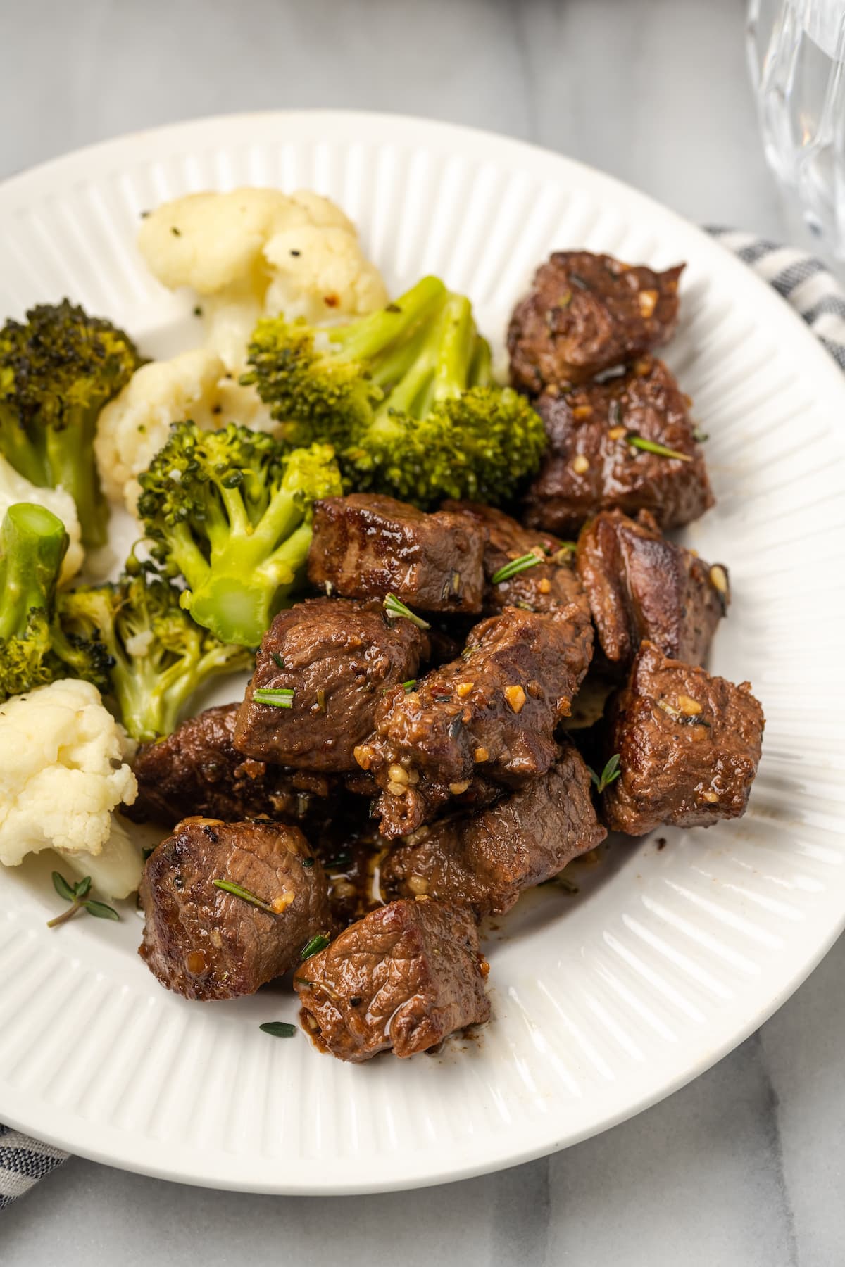 A plate full of steak bites, cauliflower, and broccoli