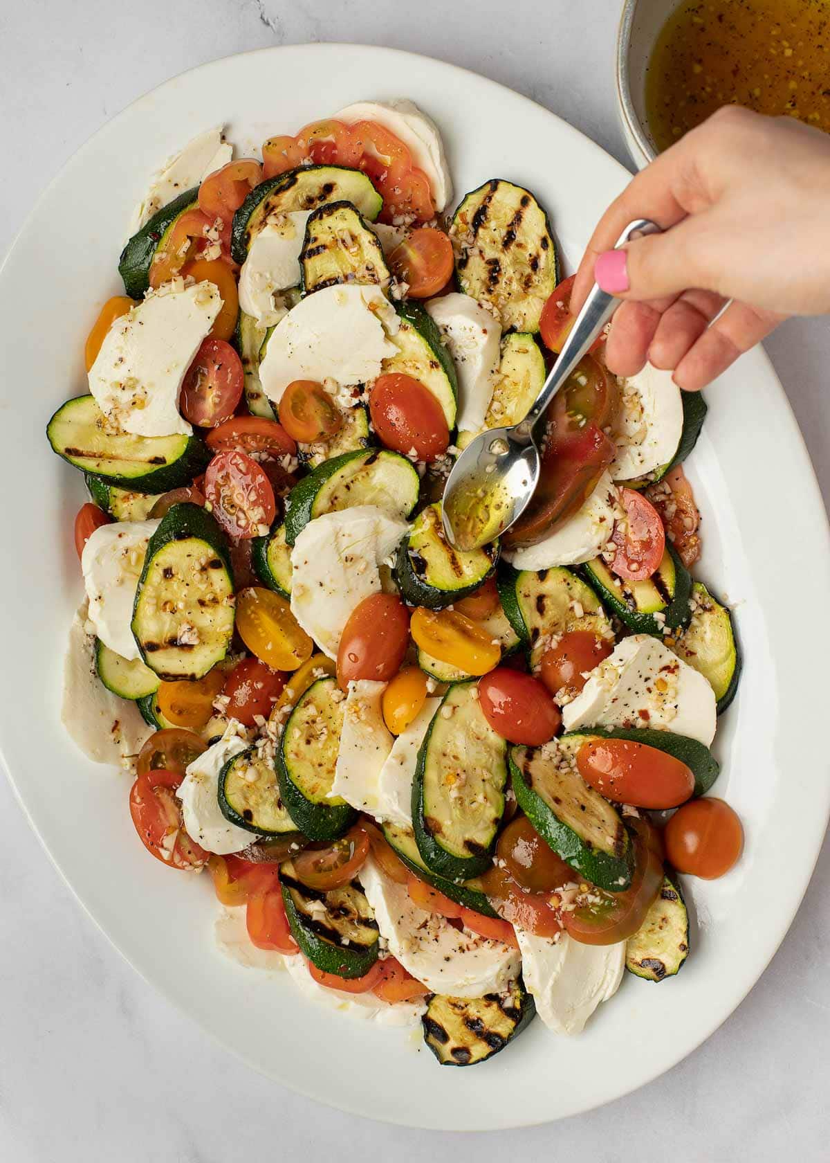 This Grilled Zucchini Salad with a homemade red wine vinaigrette will be your repeat meal of the summer! This healthy recipe is ready in under 30 minutes, loaded with fresh mozzarella and tender veggies, and has fewer than 5 net carbs.