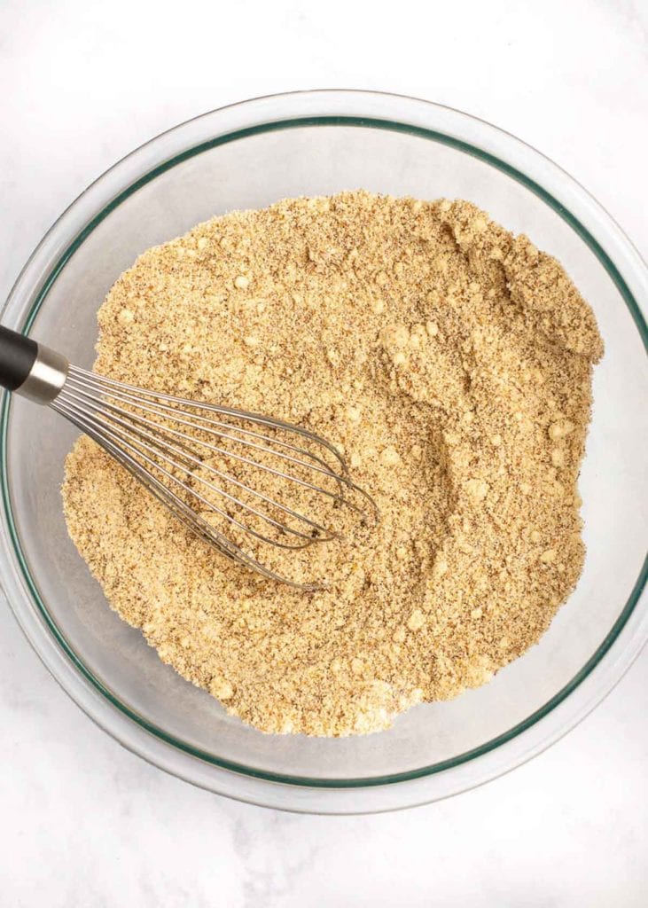 A mixing bowl with dry ingredients being whisked together