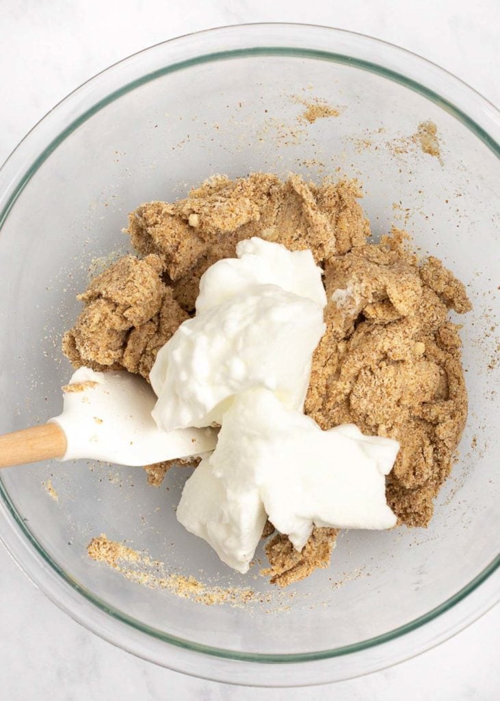 A mixing bowl with a thick dough, with a pile of whipped egg whites on top