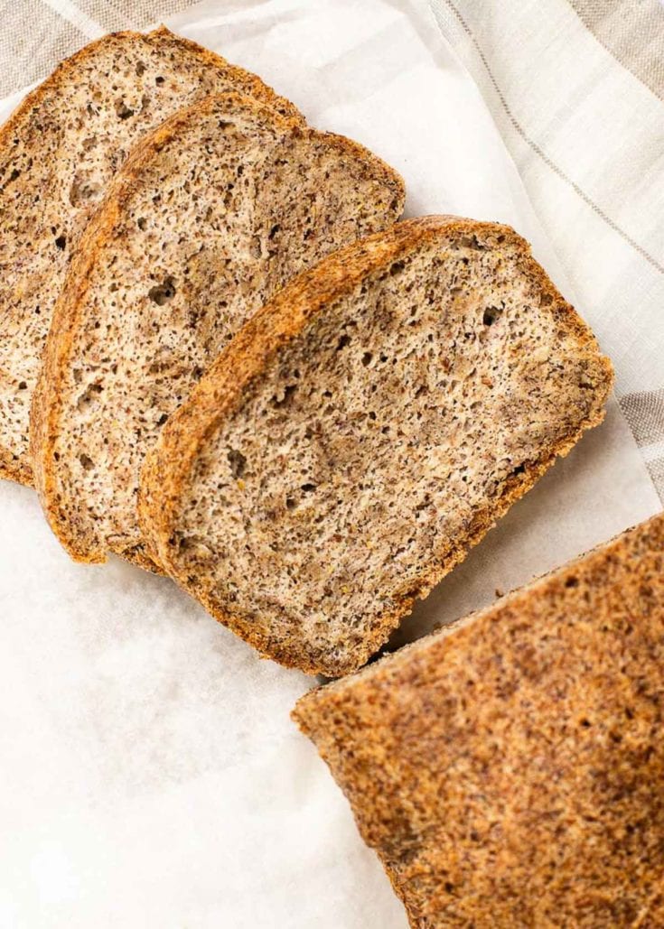 Close up of three slices of freshly baked bread next to the rest of the loaf