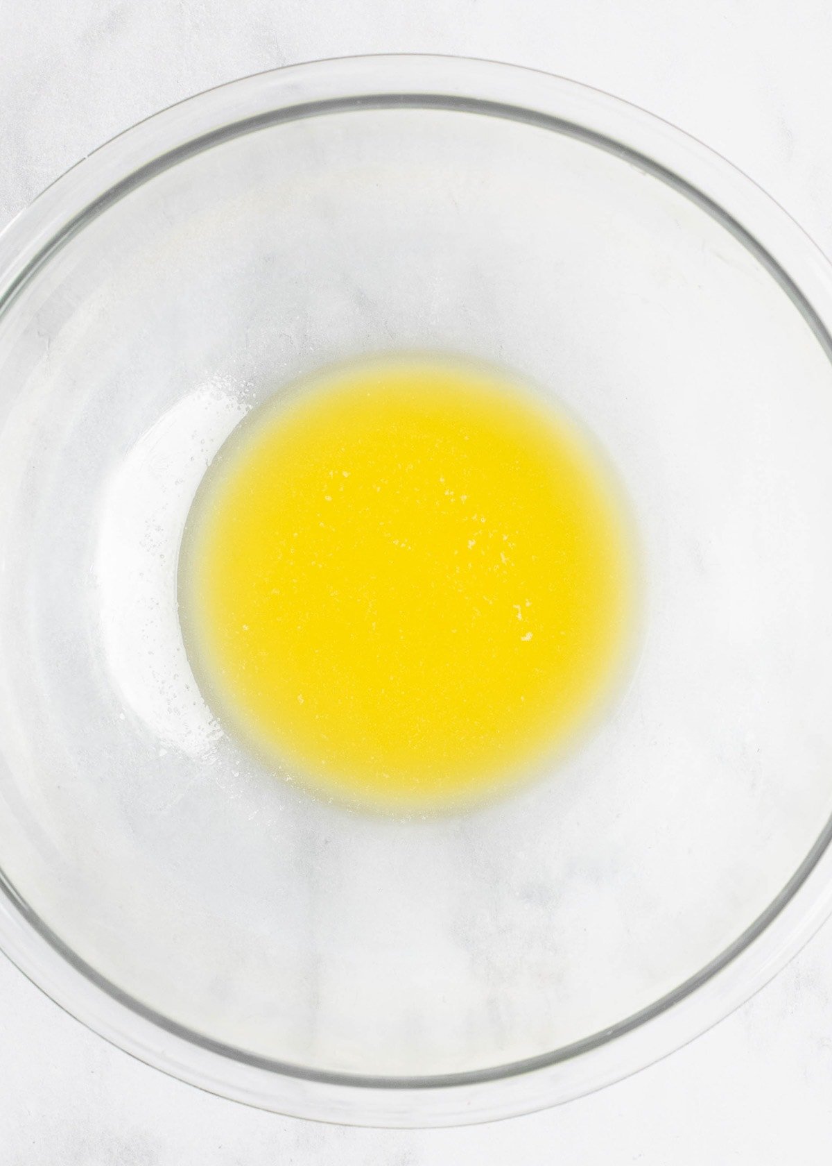 Overhead view of melted butter in a mixing bowl