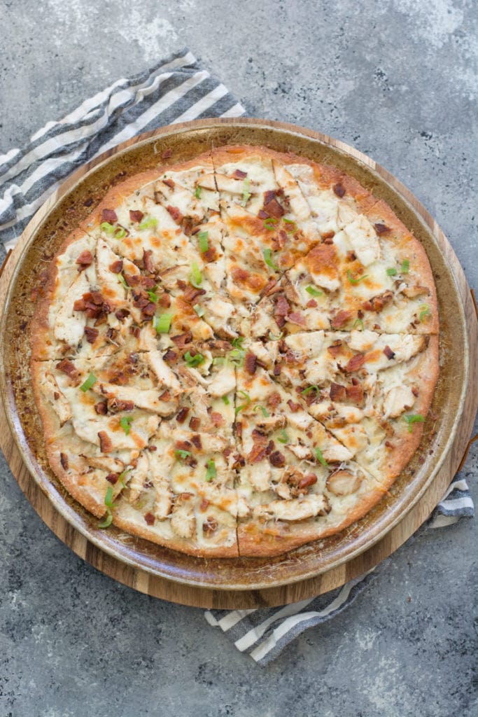 This homemade Chicken Bacon Ranch Pizza is loaded with grilled chicken, crispy bacon, a creamy ranch pizza sauce, and a perfectly crispy low carb crust! Only 3 net carbs per slice!