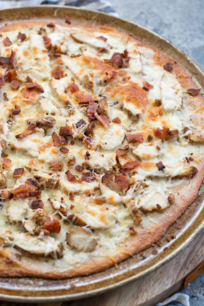 This homemade Chicken Bacon Ranch Pizza is loaded with grilled chicken, crispy bacon, a creamy ranch pizza sauce, and a perfectly crispy low carb crust! Only 3 net carbs per slice!