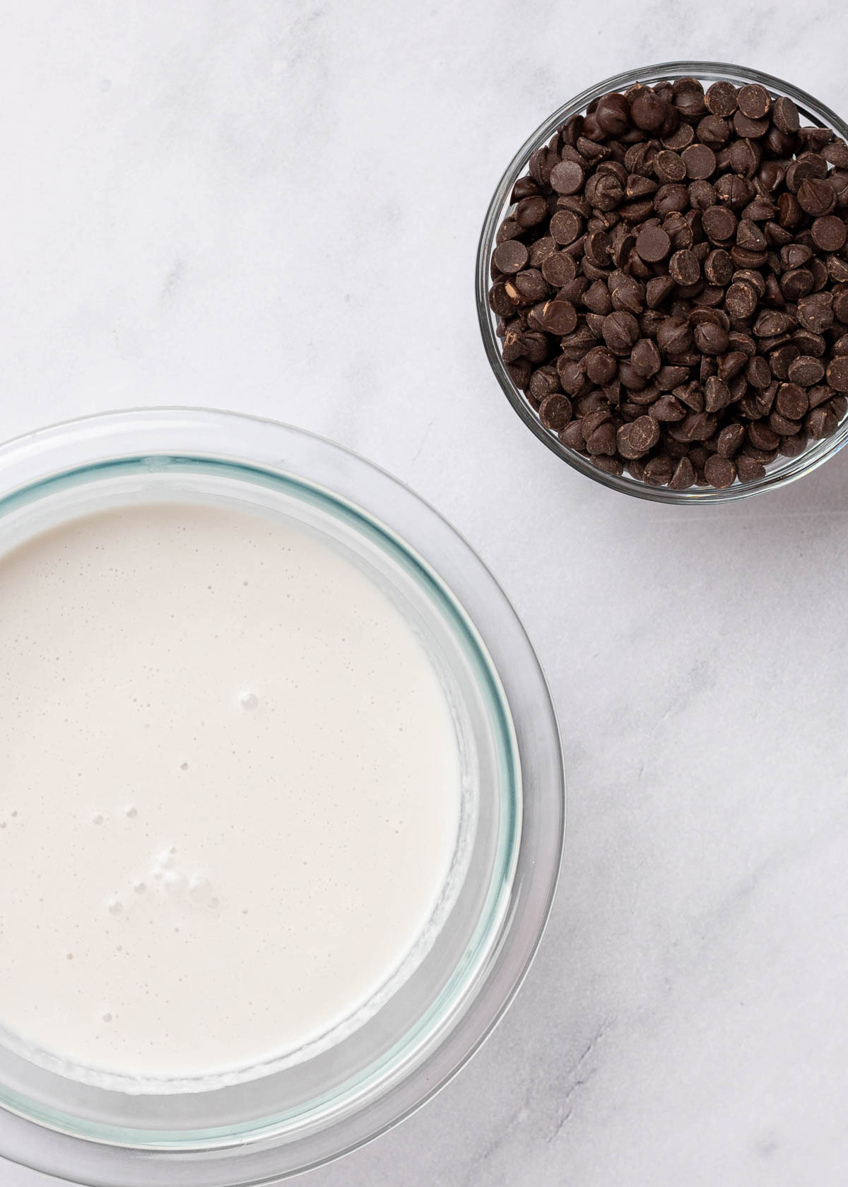 Overhead view of a bowl of chocolate chips and a bowl of coconut cream