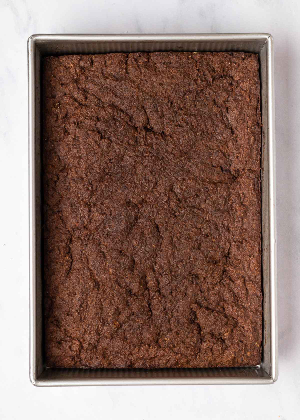 Overhead view of an unfrosted chocolate cake in a cake pan