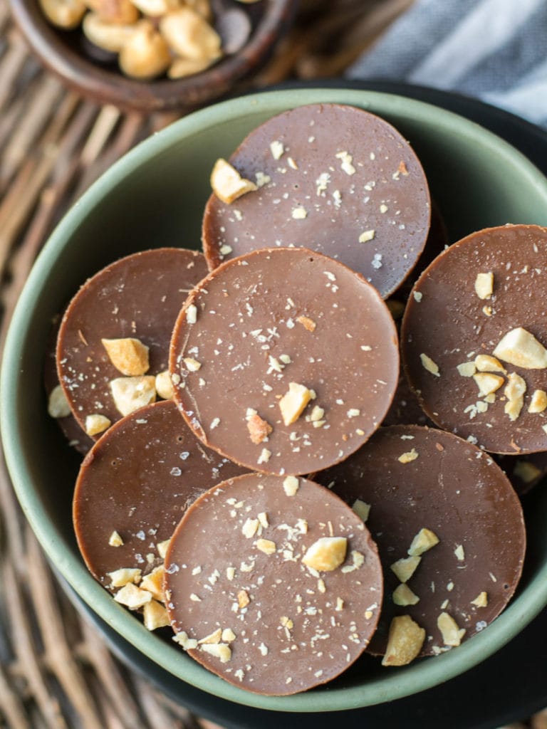 Overhead view of chocolate peanut butter fat bombs piled in a green bowl. 