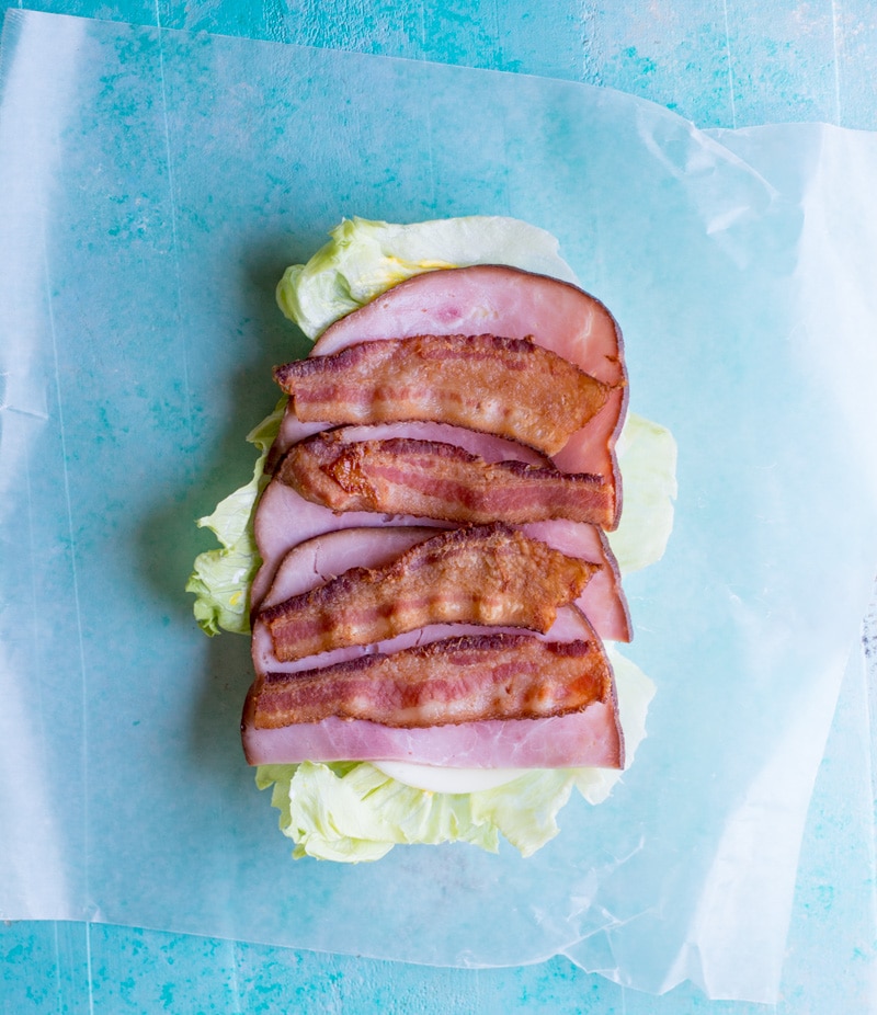 Looking for a new keto lunch? This Keto Club Lettuce Wrap is packed with thick slices of ham, bacon, cheese, crunchy lettuce and juicy tomatoes! This filling lunch is under 4 net carbs! #keto #lettucewrap