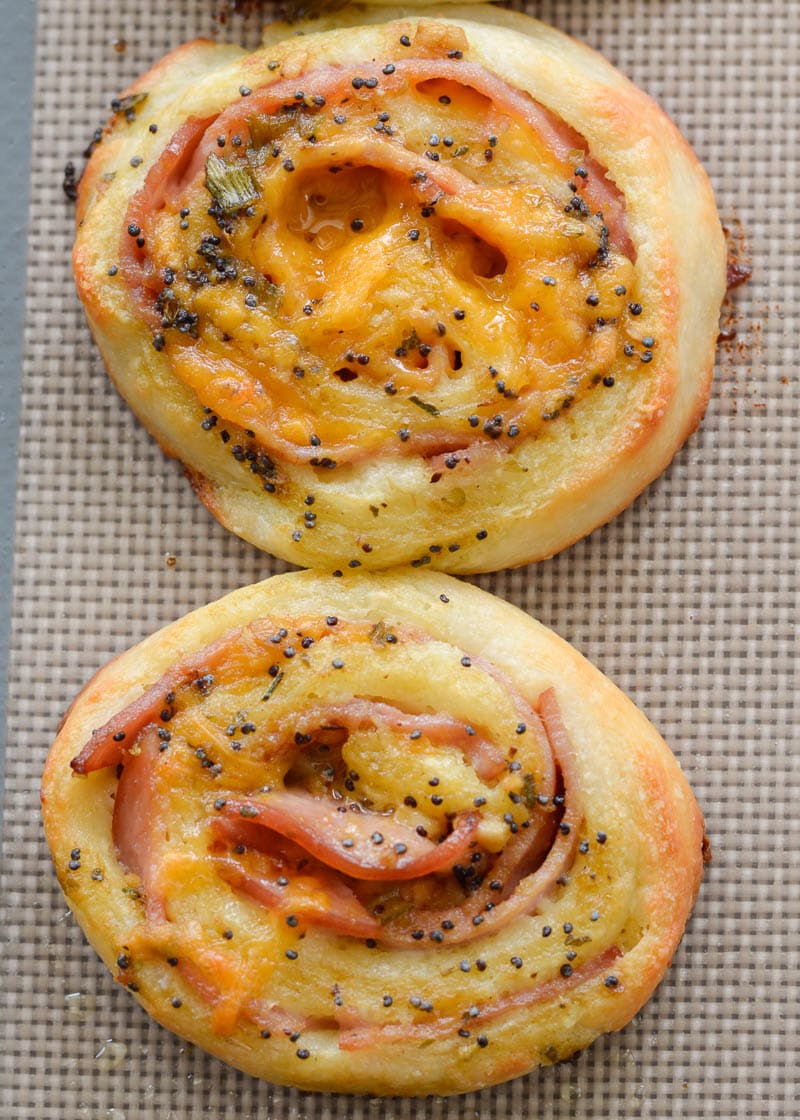 Overhead view of two baked ham and cheese pinwheels. 