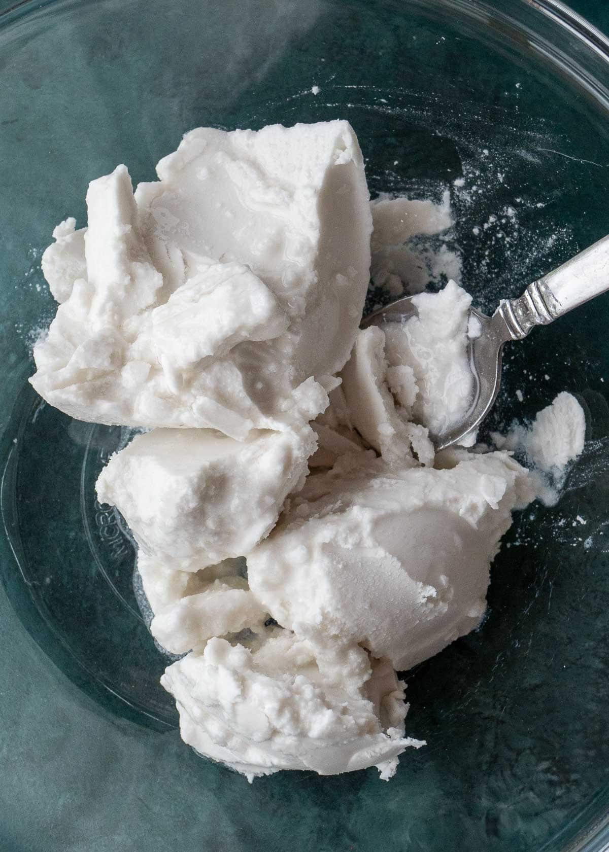 Coconut cream in a mixing bowl with a spoon