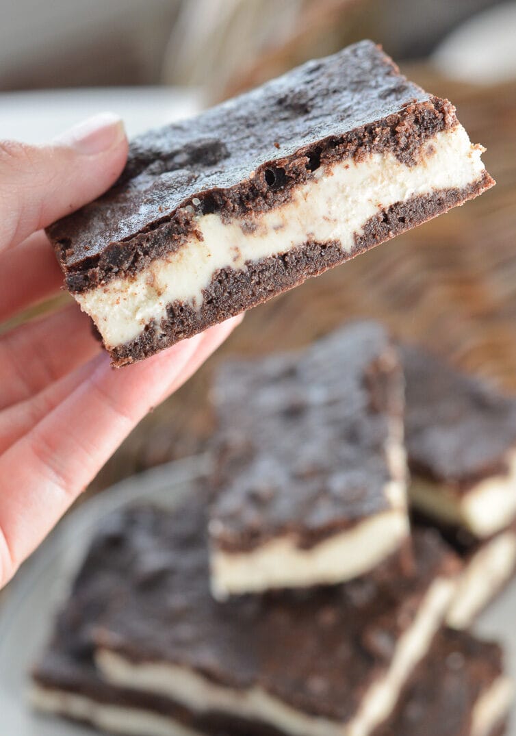 A keto almond flour brownie filled with cream cheese being held aloft. 