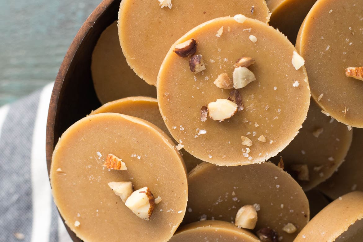 Overhead view of pieces of keto peanut butter fudge piled in a wooden bowl. 