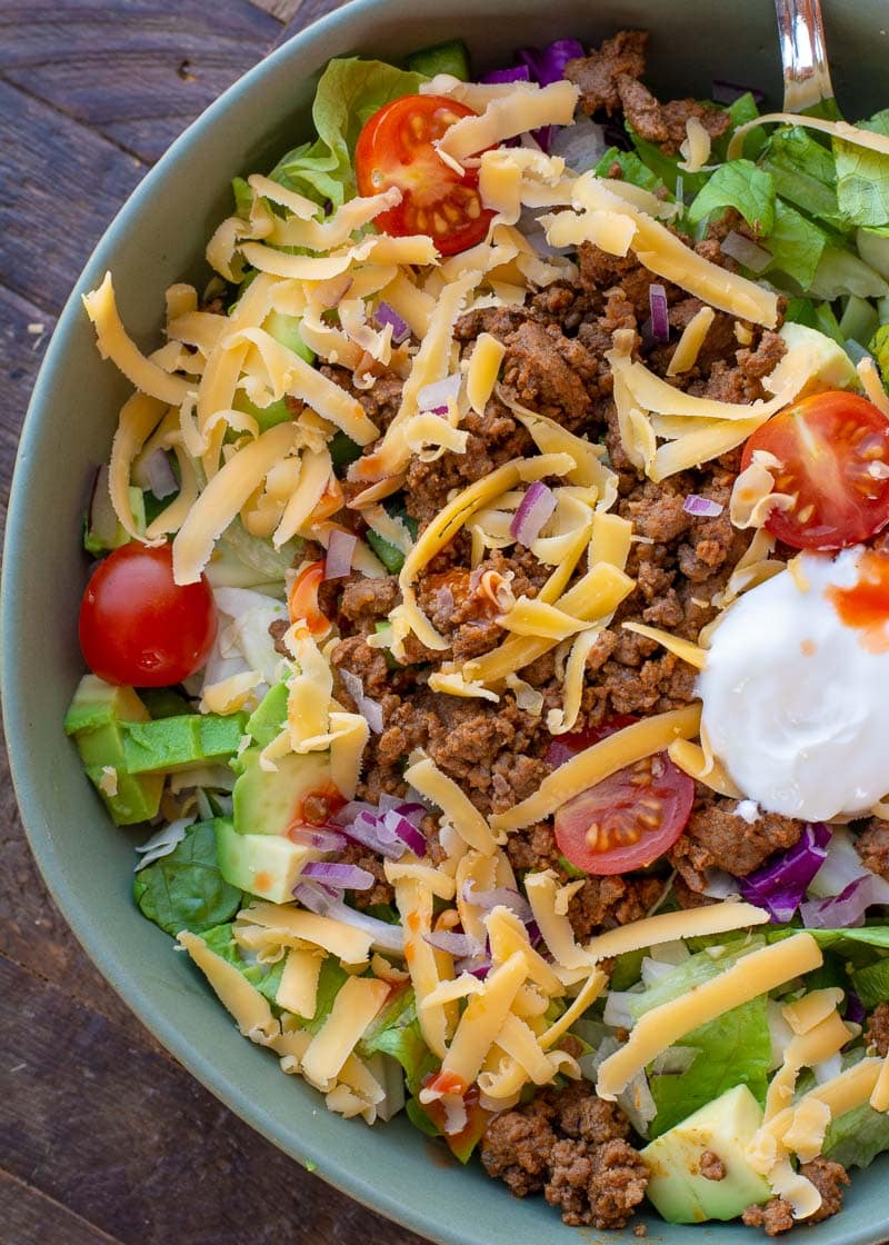 This easy Keto Taco Salad is easy, delicious, and healthy! Top your favorite greens with seasoned meat, tomato, avocado, peppers, and more for a lunch or dinner full of flavor and about 7 net carbs.