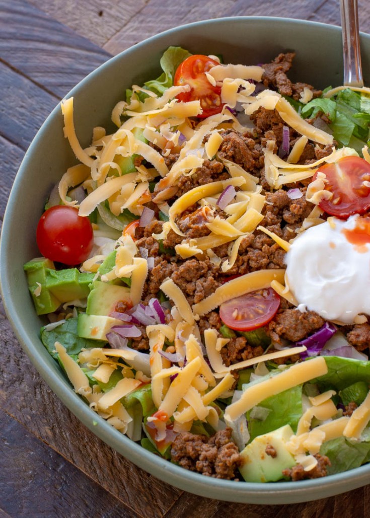 This easy Keto Taco Salad is easy, delicious, and healthy! Top your favorite greens with seasoned meat, tomato, avocado, peppers, and more for a lunch or dinner full of flavor and about 7 net carbs.