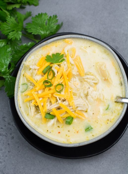 This Keto White Chicken Chili is loaded with shredded chicken, chilis, peppers and cauliflower rice! At about 7.5 net carbs per heaping serving this is the ultimate creamy keto comfort food!