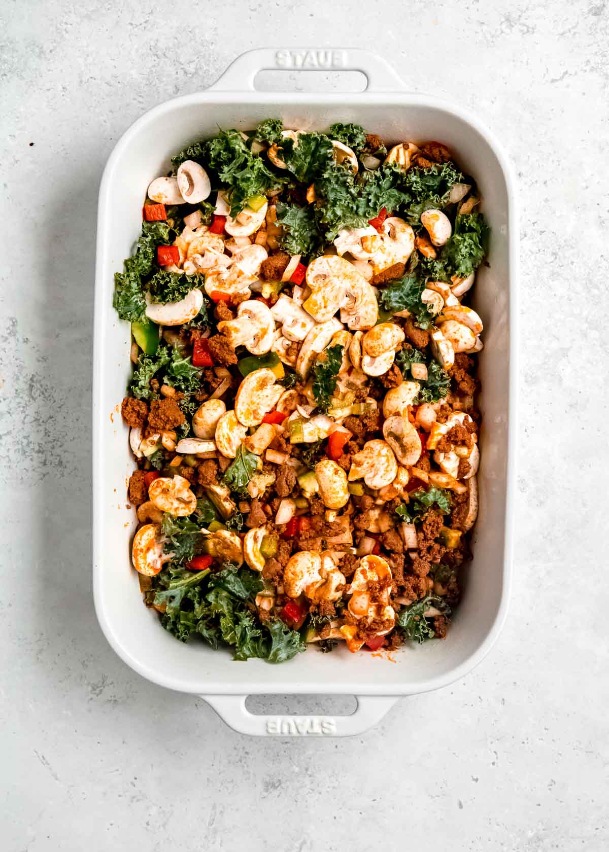 vegetables and chorizo in a white casserole dish