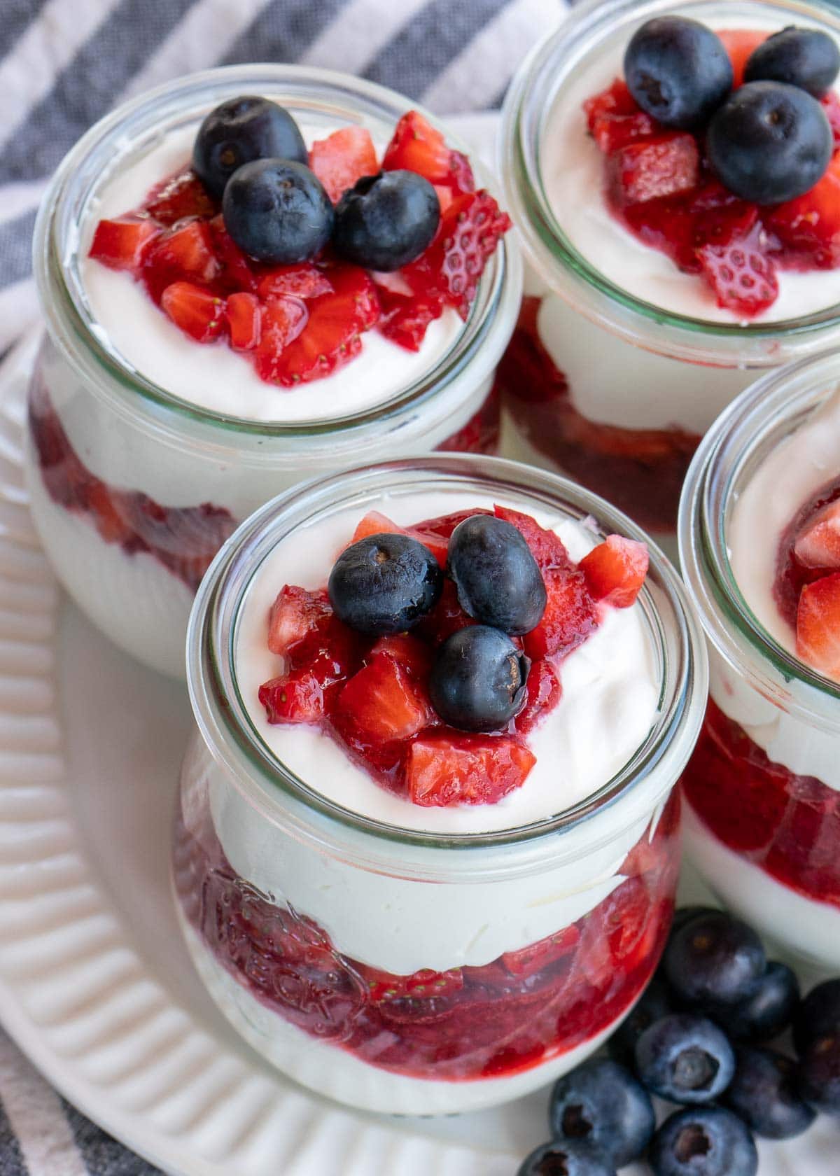 This festive No Bake Cheesecake Parfait recipe is the perfect summer treat! An indulgent cheesecake layer is paired with berries for a low-carb dessert perfect for potlucks and parties!