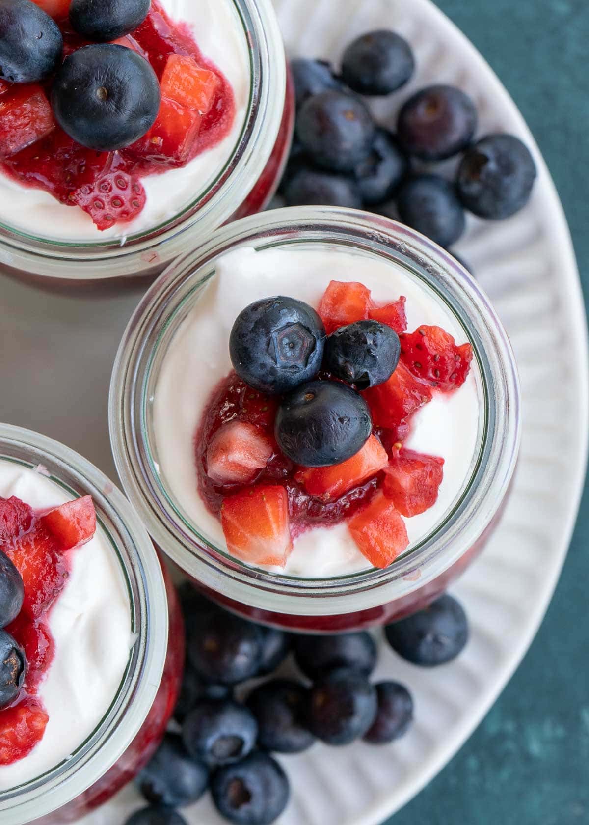 This festive No Bake Cheesecake Parfait recipe is the perfect summer treat! An indulgent cheesecake layer is paired with berries for a low-carb dessert perfect for potlucks and parties!