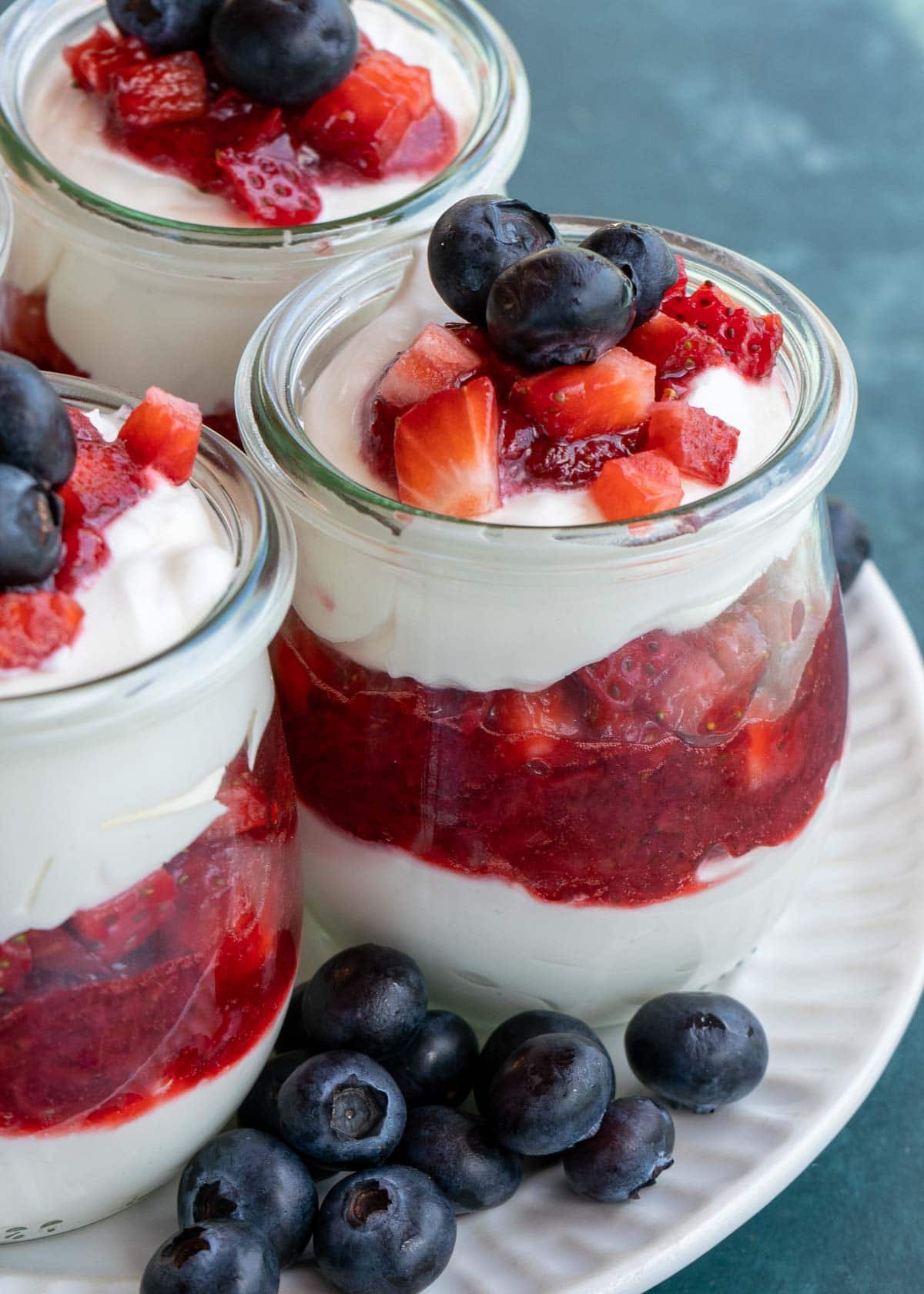 This festive No Bake Cheesecake Parfait recipe is the perfect summer treat! An indulgent cheesecake layer is paired with berries for a low-carb dessert perfect for potlucks and parties!