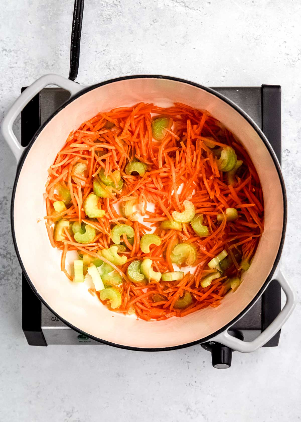 vegetables being sautéed in a dutch oven