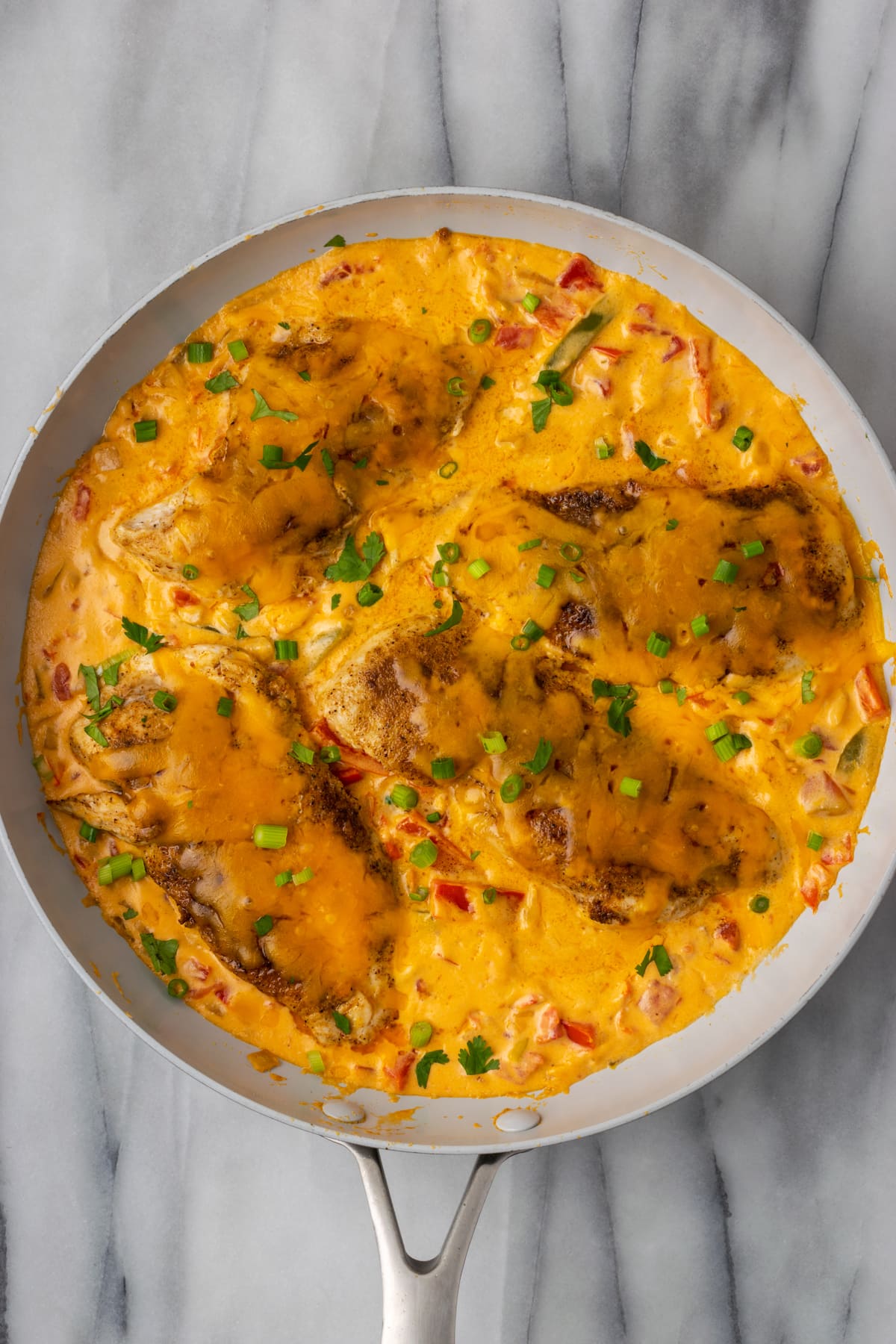 This Santa Fe Chicken is a one-pan recipe packed with your favorite southwestern flavors. Juicy seasoned chicken is paired with peppers, onions, and tomatoes in a creamy, cheesy sauce!