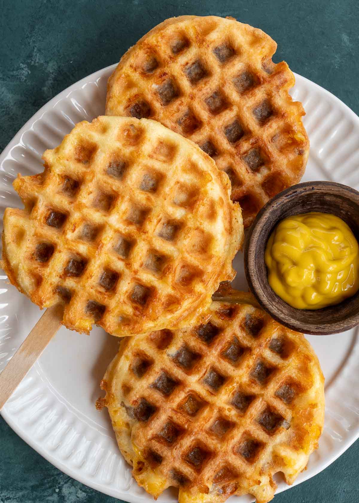 chaffles stuffed with sausage on a plate with mustard