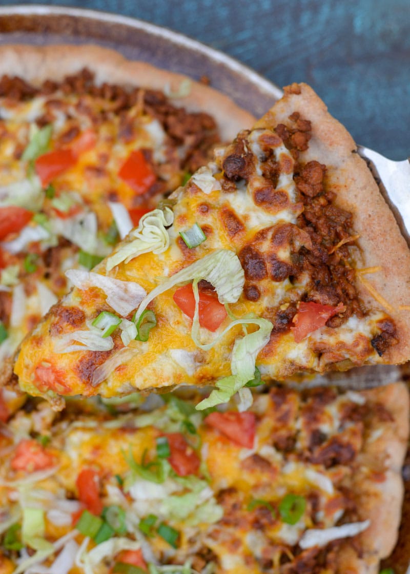 Enjoy a slice of cheesy Taco Pizza topped with all of your favorite Mexican fixings! This low carb pizza recipe has just 5 net carbs per slice and is loaded with flavor!