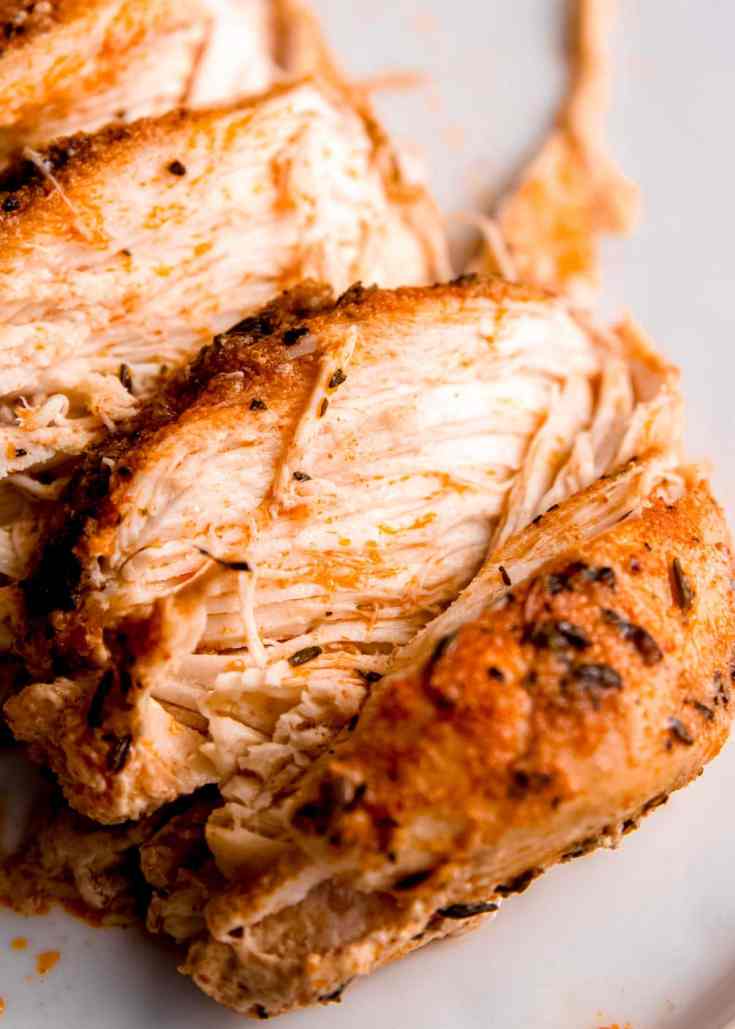 sliced slow cooker chicken breast on white plate